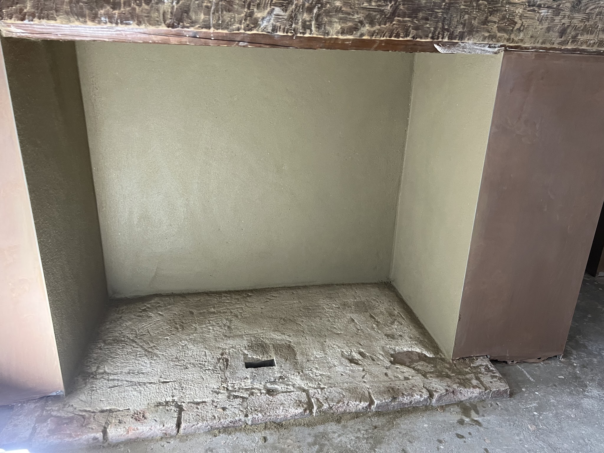 A fireplace recess freshly plastered